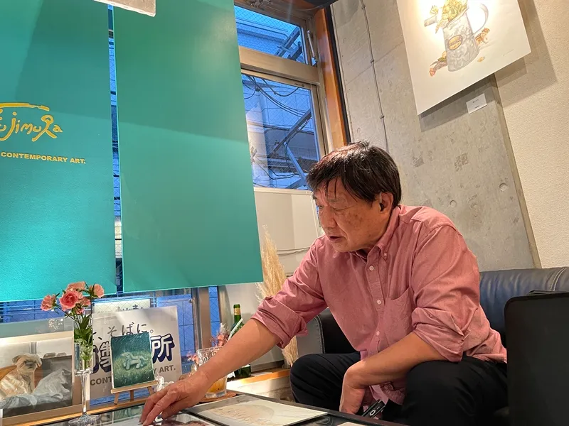 ギャラリーで打ち合わせするのりゆき画伯の写真